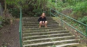 Natural redhead Chrissy Fox squats for a pee on a set of public steps on dollser.com
