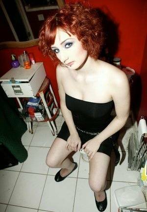 Pale redhead Violet Monroe gets naked in flat shoes while in a bathroom on dollser.com