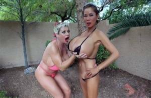 Big titted older women Claudia Marie and Minka kiss outdoors in skimpy bikinis on dollser.com