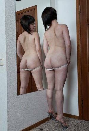 White teen with a full bush admires herself in mirror while disrobing on dollser.com