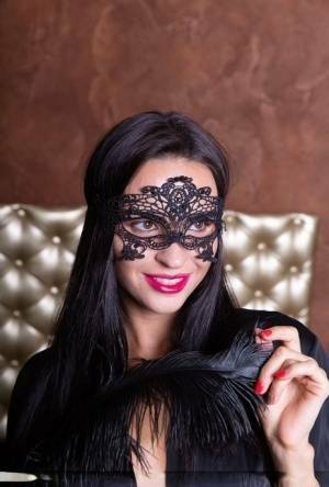 Sexy brunette Leyla Lee removes a mask and robes to pose nude with a feather on dollser.com