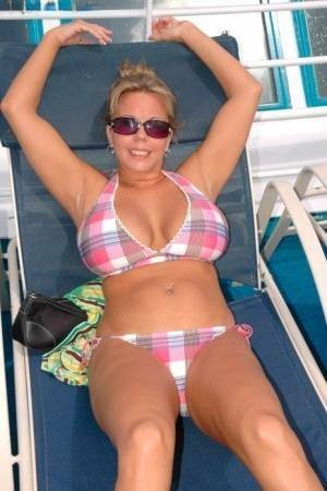 Hugely busty Amber Lynn Bach doffs her bikini to spread her legs wide nude on dollser.com