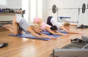 Young girls stretch out on yoga mats before commencing a lesbian threesome on dollser.com