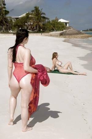 Fervent lesbians stripping nude and playing with dildos on the beach on dollser.com