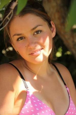 Petite amateur Allie Haze shows her tan lined body in the shade of a tree on dollser.com