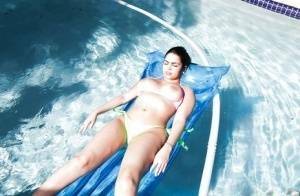 Brunette babe model Ada S going topless on air mattress in swimming pool on dollser.com