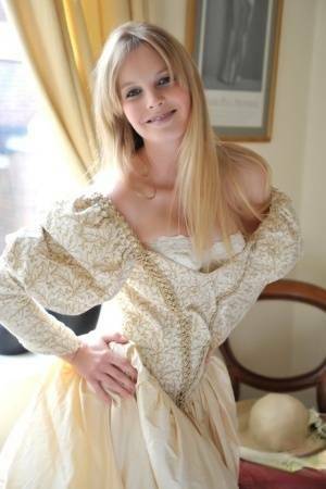 Blonde girl Rose takes off her petticoat to model in a girdle and nylons on dollser.com