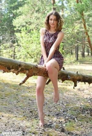 Nice young girl Ari gets completely naked while in a forested area on dollser.com